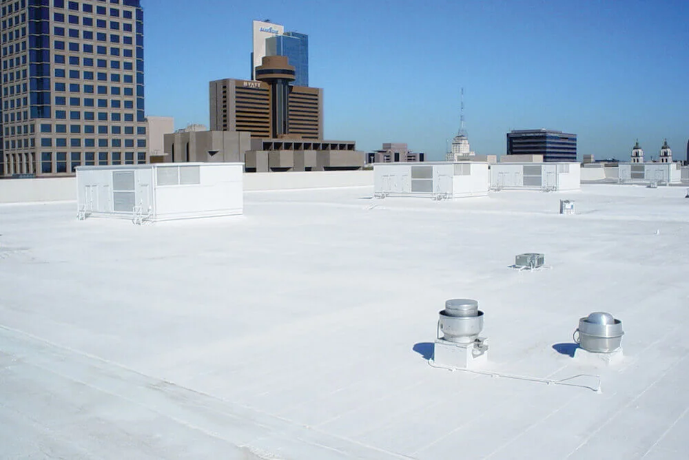 A large white commercial roof across a city skyline